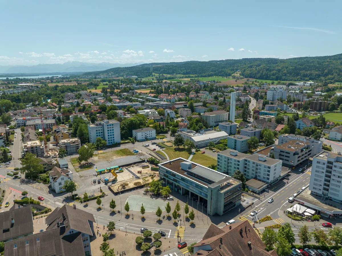 Drohnenaufnahme einer auf ein Stadtzentrum mit Baulücke.